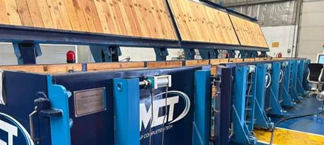 MCT in-house pressure testbay in the Jafza facility: a row of blue and navy test cells under timber-topped covers.